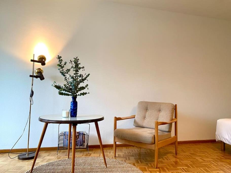 Modern 3-bedroom apartment in city centre في بازل: غرفة معيشة مع كرسي وطاولة