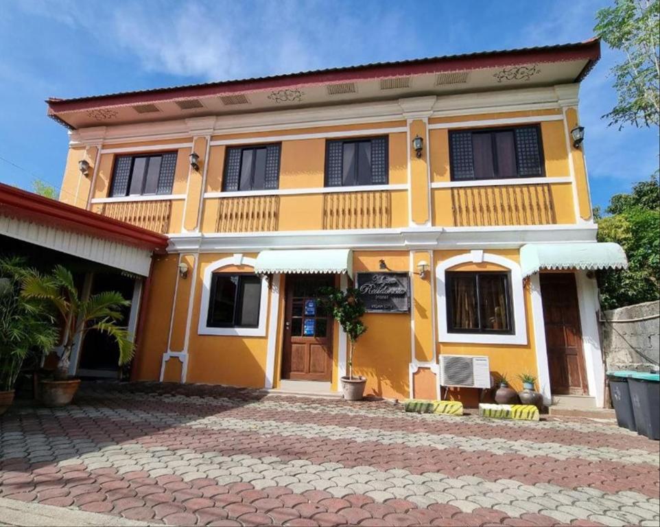 una casa amarilla con techo rojo en Mojica Residencia en Vigan