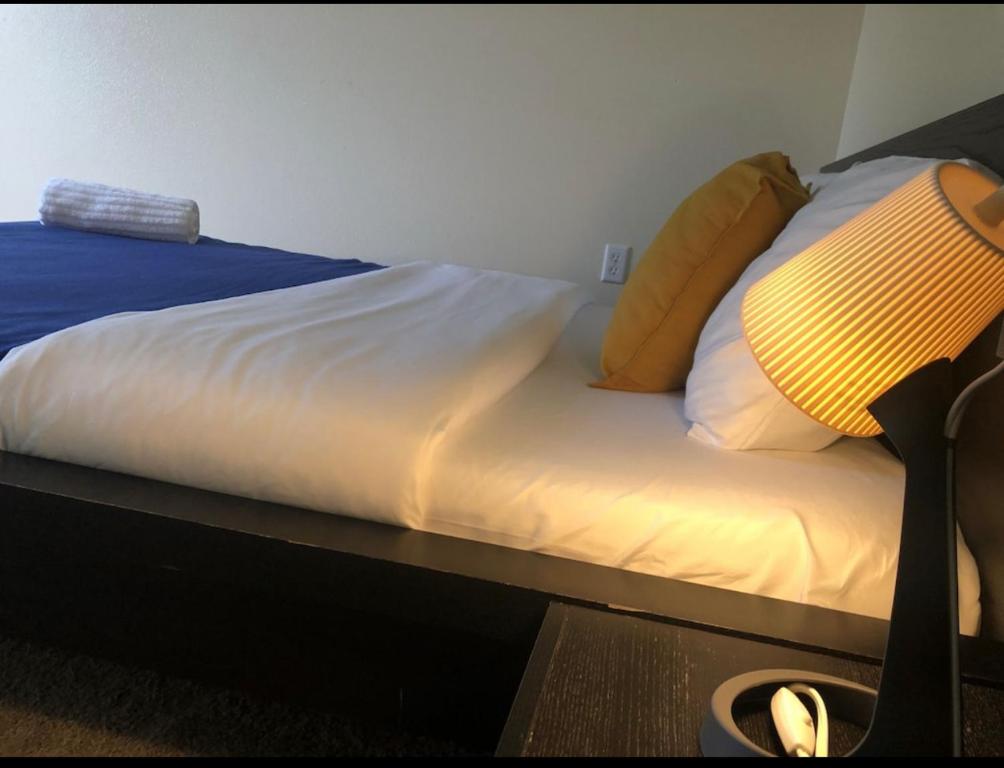 1 cama con sábanas blancas y almohadas amarillas en Avalon Stay 7 nights minimum booking, en Jacksonville