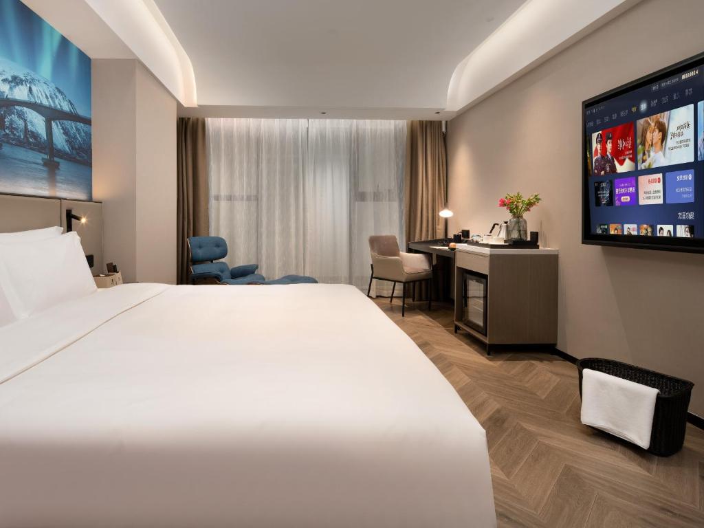 Postel nebo postele na pokoji v ubytování Echarm PLUS International Hotel Zhujiang New Town Wuyangcun Metro Station - Free Deliver Service to Canton Fair Complex During Canton Fair Period