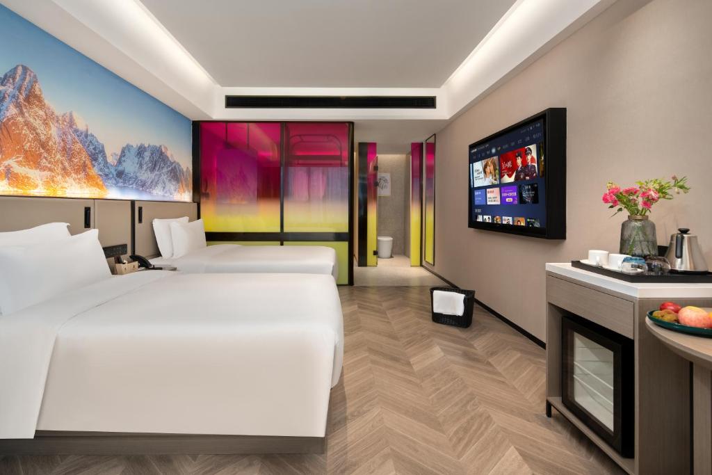 Postel nebo postele na pokoji v ubytování Echarm PLUS International Hotel Zhujiang New Town Wuyangcun Metro Station - Free Deliver Service to Canton Fair Complex During Canton Fair Period