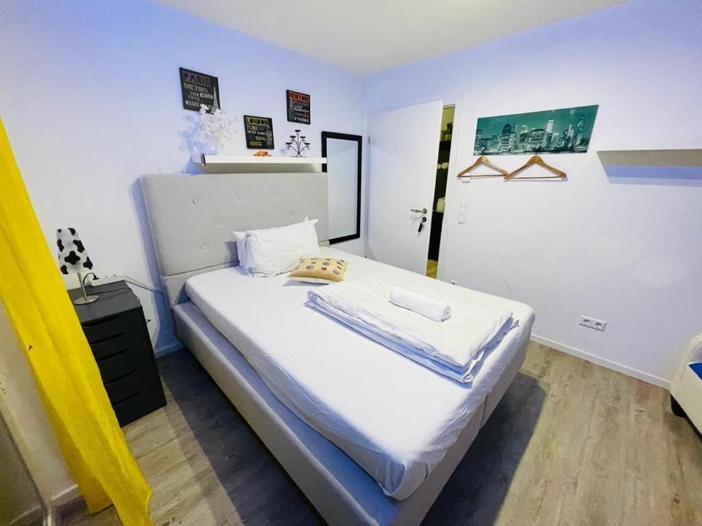 a small bedroom with a bed with white sheets at Plaza 112A RioFlats in Stuttgart