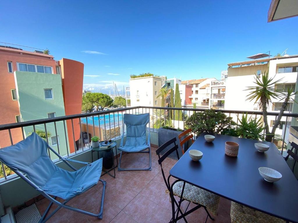 d'une terrasse avec une table bleue et des chaises sur un balcon. dans l'établissement Family apartment - terrace - parking - 4-5 people, à Antibes