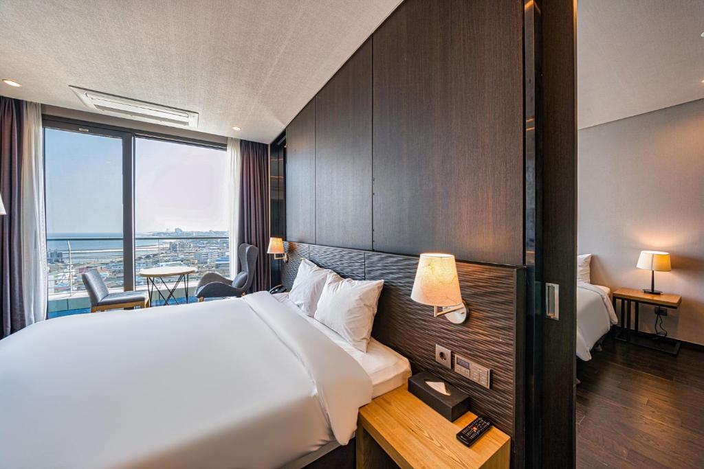 Postel nebo postele na pokoji v ubytování SL Hotel Gangneung