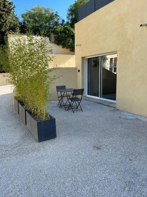 un patio avec deux chaises et une table à côté d'un bâtiment dans l'établissement Grand Studio au Rdc dans résidence, clim, terrasse, à Martigues