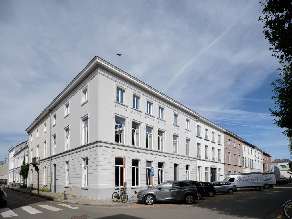 un edificio blanco con coches estacionados frente a él en CE RESIDENCE, en Gante