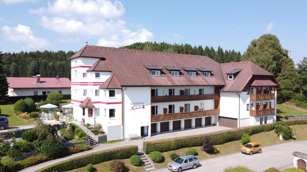 a large white building with a brown roof at Hotel Gästehaus Neubauer in Kaltenberg