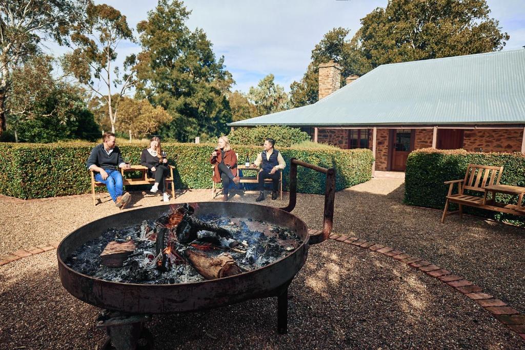 een groep mensen die rond een vuurplaats zitten bij Jacobs Estate Cottage in Rowland Flat