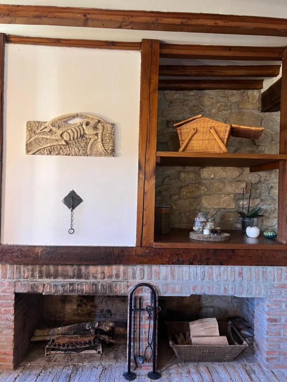 een stenen open haard met een houten mantel bij Casa Rural Basiver - Habitación Pico Samelar in Armaño