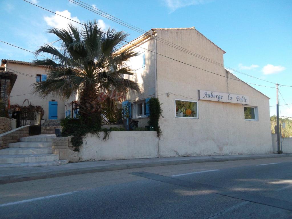 un edificio con una palmera al lado de una calle en Auberge La Folie en Sausset-les-Pins