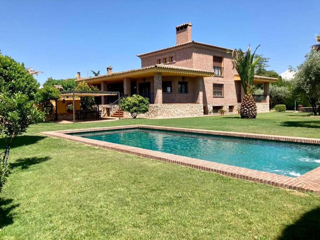 a house with a swimming pool in front of a house at LUXURY Positive House Gran Chaparral Toledo in Pepino