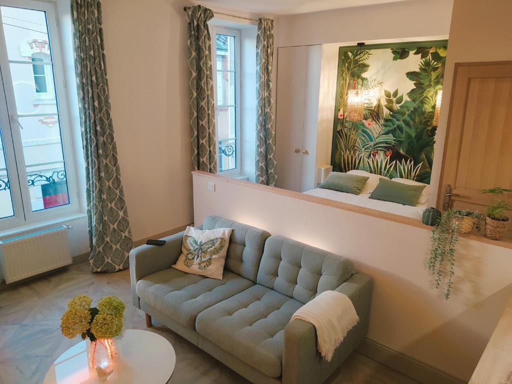 uma sala de estar com um sofá e um espelho em Ô Bulles de Loire, Châteauneuf-sur-Loire em Châteauneuf-sur-Loire