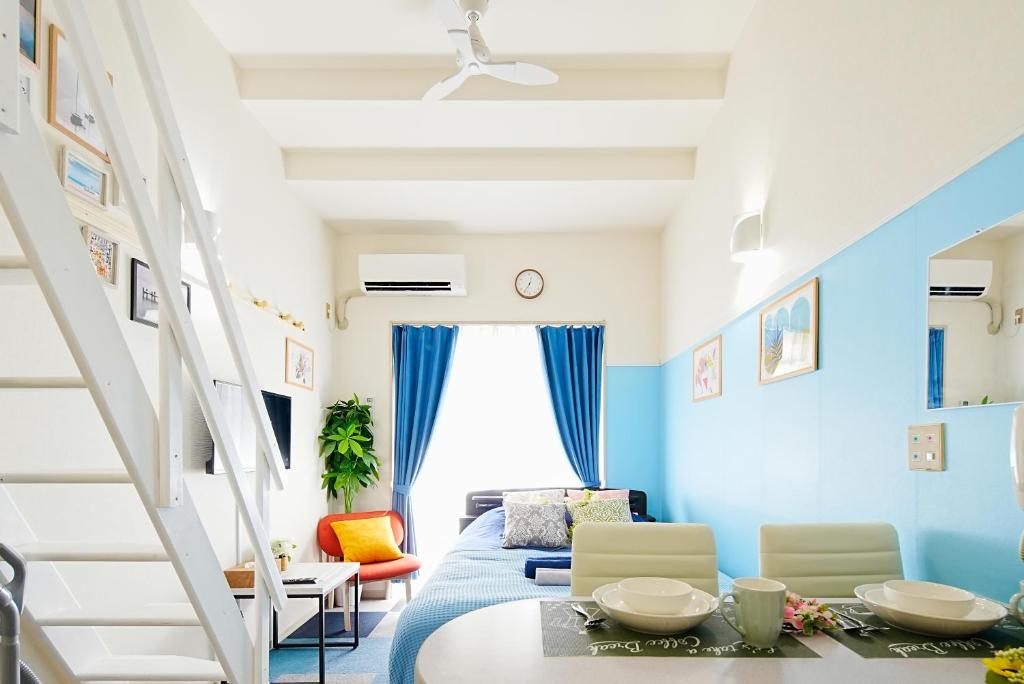 Cette chambre est dotée de murs bleus, d'un lit et d'une table. dans l'établissement SC Heights 101, à Tokyo