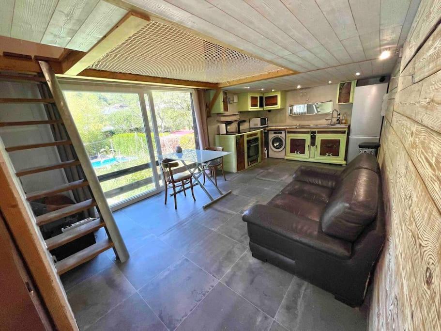 a living room with a leather couch in a tiny house at La tiny house de Chaparon in Lathuile