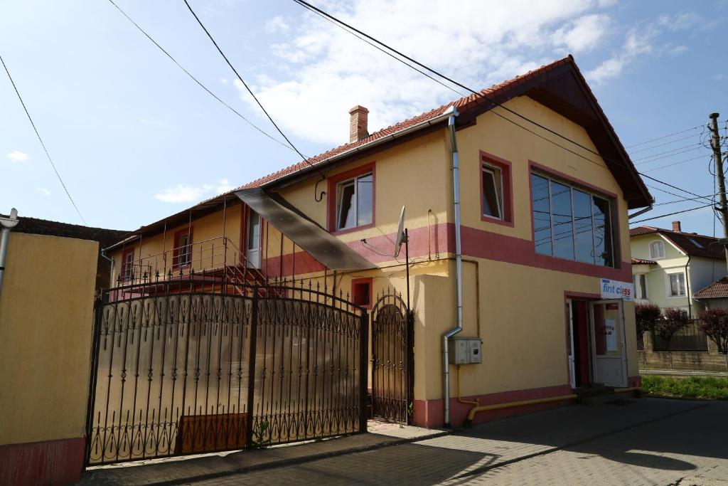 a yellow and red house with a gate at Pensiunea Driver in Orăştie