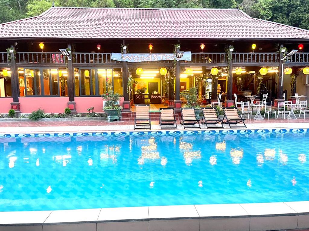 a large swimming pool in front of a building at Woodstock Beach Camp in Cat Ba