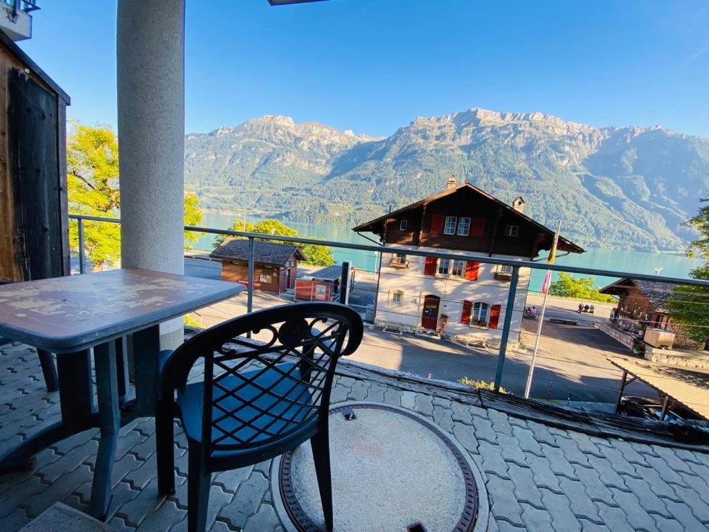einen Tisch und einen Stuhl auf einem Balkon mit Bergblick in der Unterkunft LakeSide Villa - 18 in Niederried
