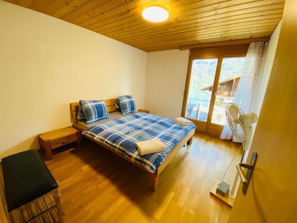 a bedroom with a bed and a large window at LakeSide Villa - 18 in Niederried