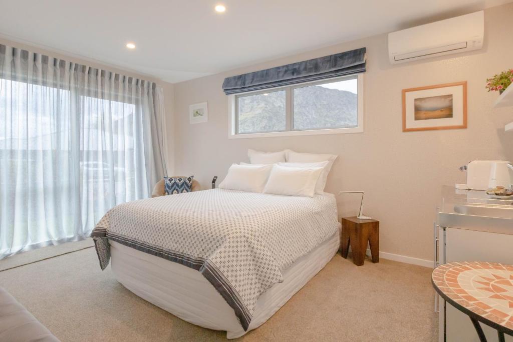 a bedroom with a bed and a window at Queenstown Modern Studio at Arthurs Point in Queenstown