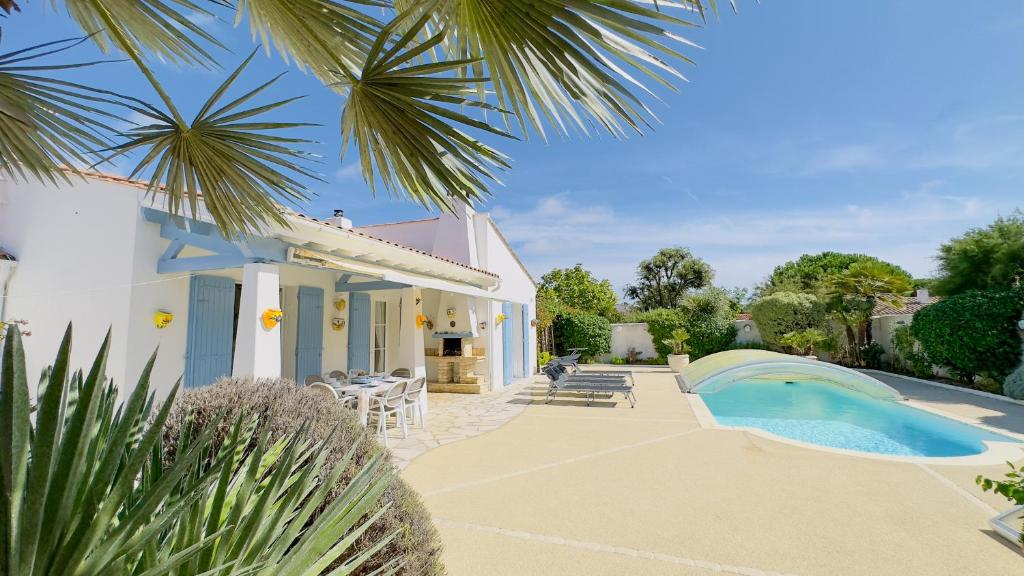 eine Villa mit Swimmingpool und ein Haus in der Unterkunft Villa de plain pied avec jardin paysager et piscine in Ars-en-Ré