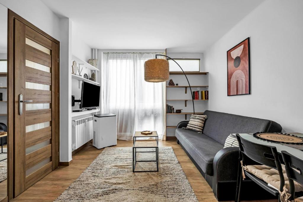 een woonkamer met een bank en een tafel bij Jana Pawła II Comfort Apartments by Rentujemy in Warschau