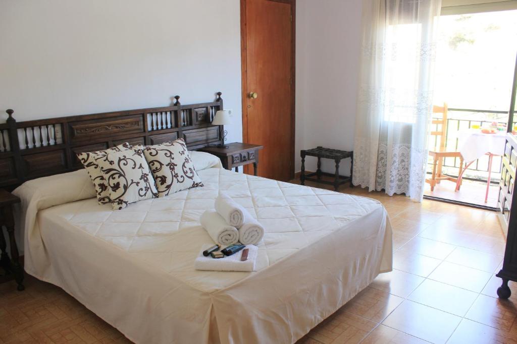 a bedroom with a bed with two towels on it at Pensión Algarrobeña in Algarrobo