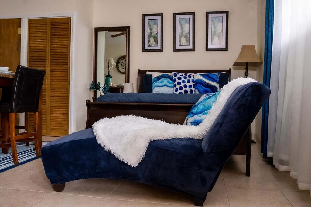 a bedroom with two beds and a blue couch at A Taste of Paradise - Vacation Rentals close to US Embassy & Restaurants in Nassau