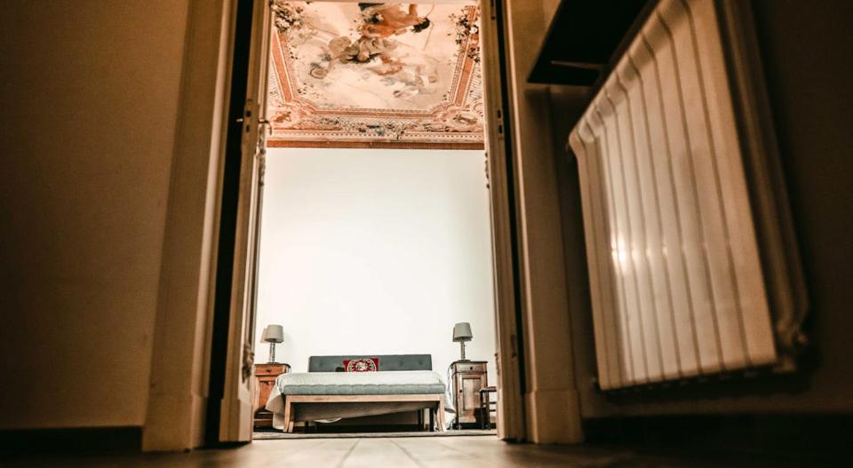 une porte ouverte menant à une chambre avec un lit dans une pièce dans l'établissement Domus Antica, à Santa Maria Capua Vetere