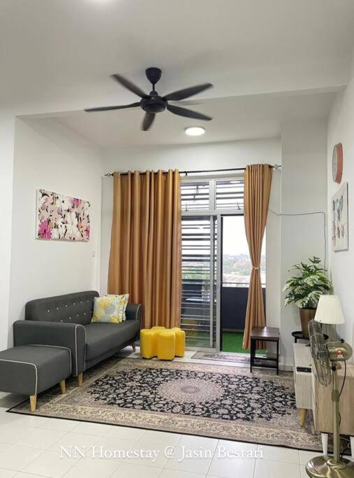 a living room with a couch and a ceiling fan at NN Homestay @ Jasin Bestari in Kampong Bemban