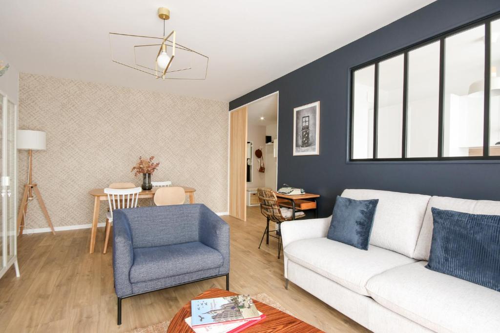 a living room with a white couch and a blue chair at La Belle Epoque - Proche Gare - Parking Gratuit in Angoulême