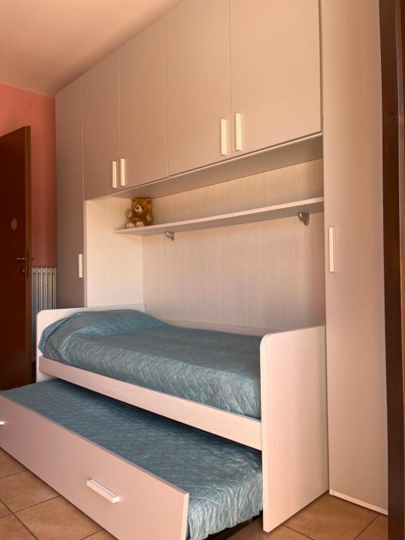 um quarto com prateleiras e uma cama num quarto em Bianchi &Bianchi casa vacanza Laveno-Mombello em Laveno