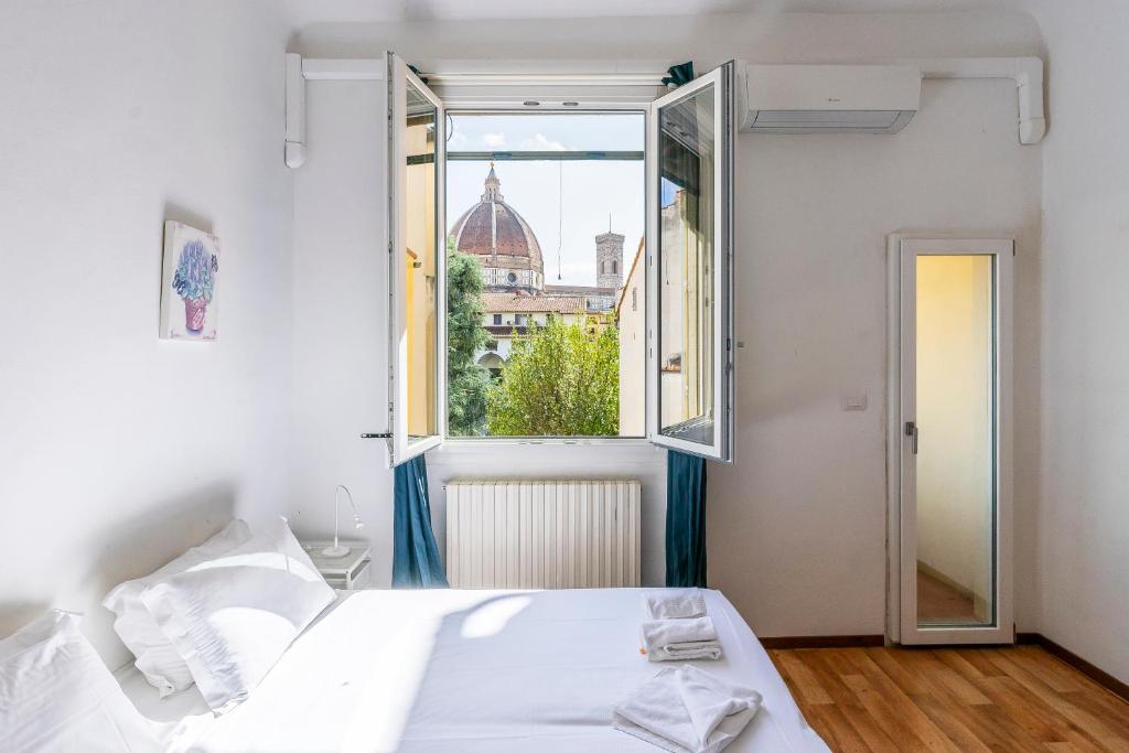 sypialnia z białym łóżkiem i oknem w obiekcie Alfani 63 Apartment we Florencji
