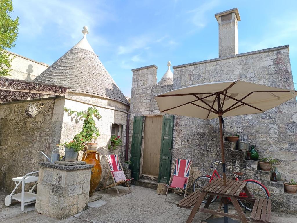 a patio with a table and an umbrella at Trullo Galeotto in Martina Franca