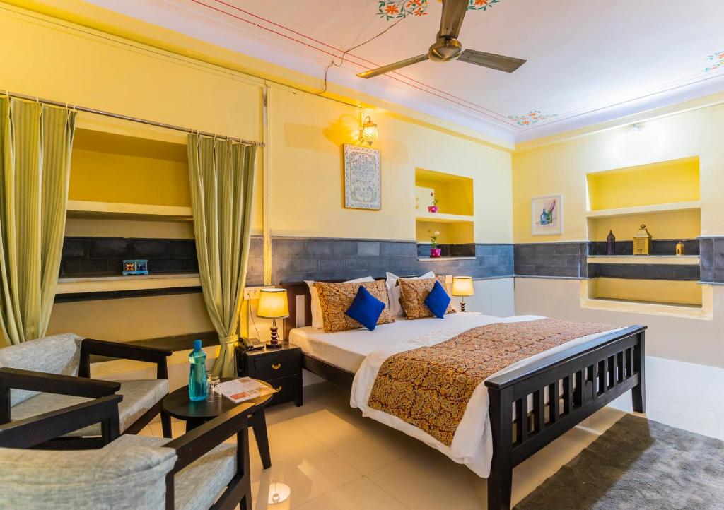 Kalyan Villa Homestay في أودايبور: غرفة نوم بسرير واريكة وطاولة