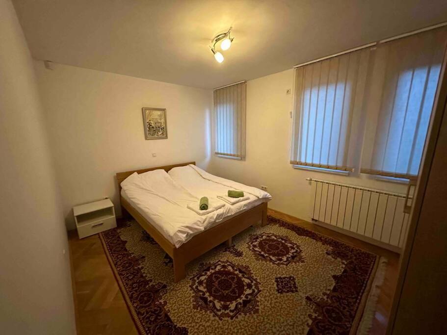 ein kleines Schlafzimmer mit einem Bett und einem Teppich in der Unterkunft Villa Bastion in Sarajevo