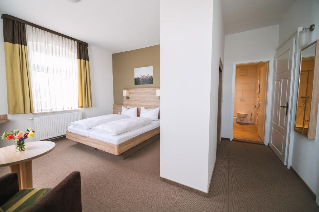 a hotel room with a bed and a bathroom at Gasthof Drei Schwanen in Langenwetzendorf