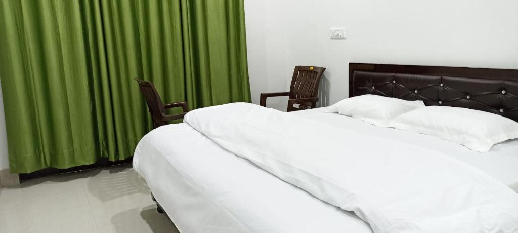 1 dormitorio con 2 camas blancas y cortinas verdes en RADHA BNB ( HOMESTAY ), en Dharamshala