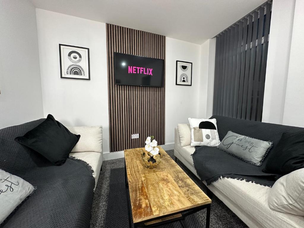 ein Wohnzimmer mit 2 Sofas und einem Tisch in der Unterkunft The En-Suite Escape. 4-Bed Luxury Stay in Castleford