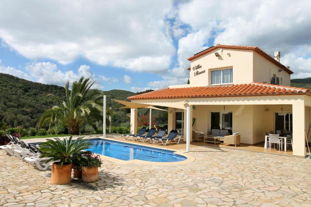 a villa with a swimming pool and a house at Villa Rosa in Calonge