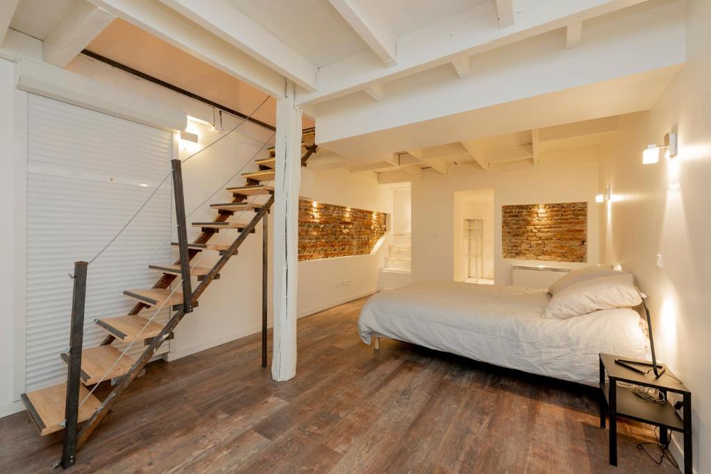 une chambre avec un lit et un escalier en colimaçon dans l'établissement L'Aubuisson - Apt Climatisé Avec Terrasse Privée, à Toulouse