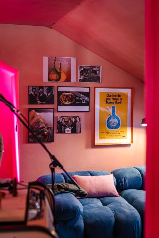 A blue sectional sofa and gallery wall in a vividly lit communal lounge.