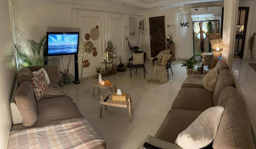 a living room with two couches and a tv at شقة مفروشة في المسعودي in Al Ain