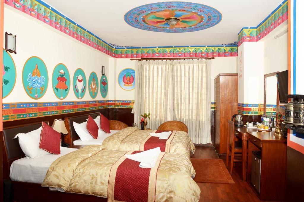 1 dormitorio con 2 camas y escritorio. en Kathmandu Eco Hotel, en Katmandú