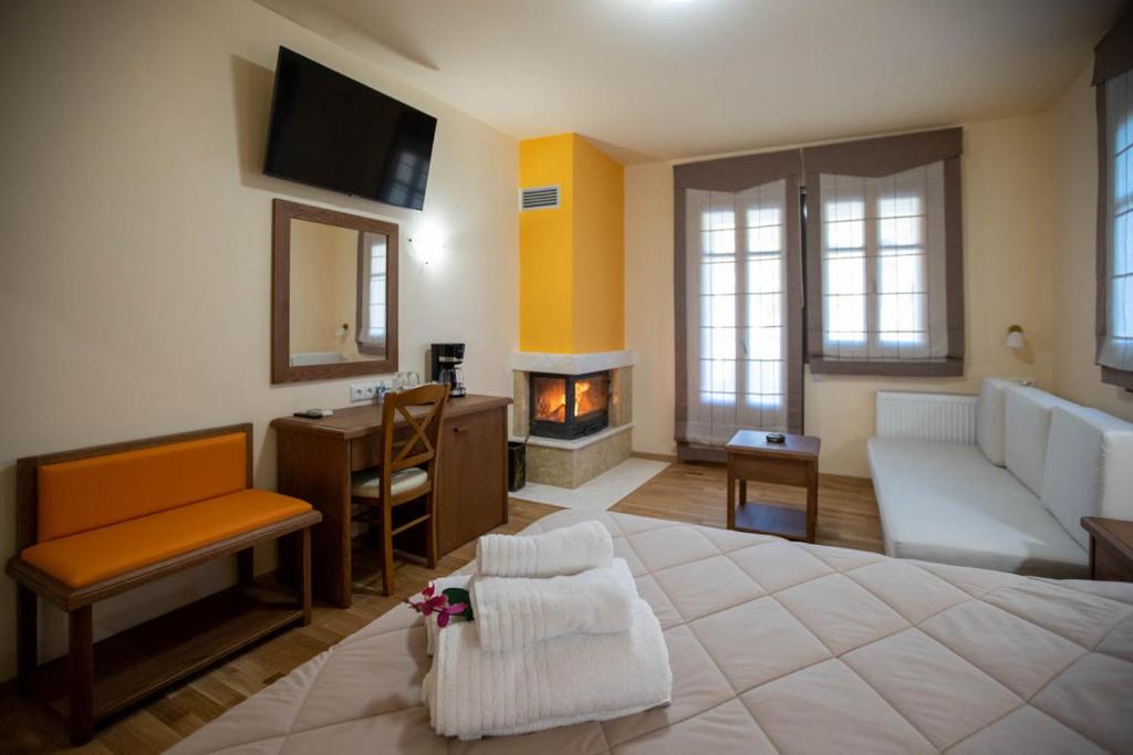 een slaapkamer met een groot bed en een open haard bij Rentinia Inn in Rentína