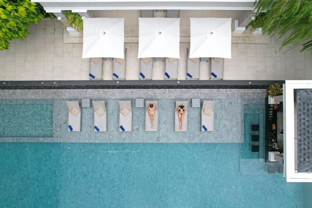 Una vista aérea de una piscina con dos personas de pie al sol. en The Beverly Hotel Pattaya, en Pattaya South