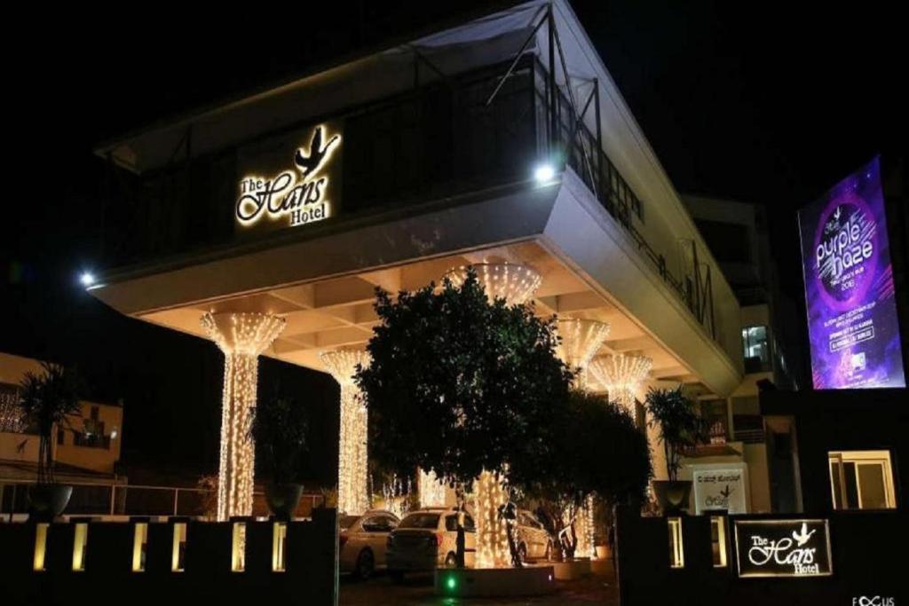 a building with a sign on it at night at The Hans Hotel in Hubli