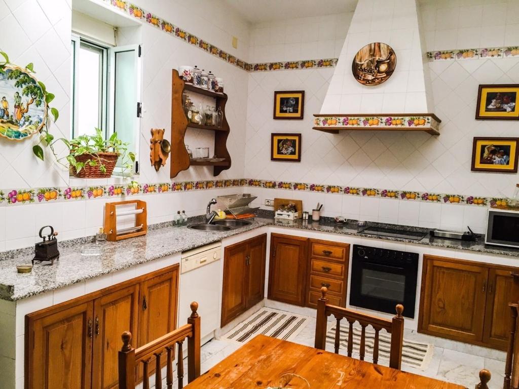 cocina con armarios de madera y mesa de madera en La Casa de Manolo, en Cazalla de la Sierra