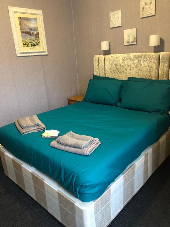 a bed with blue sheets and towels on it at Briny View Hotel in Blackpool