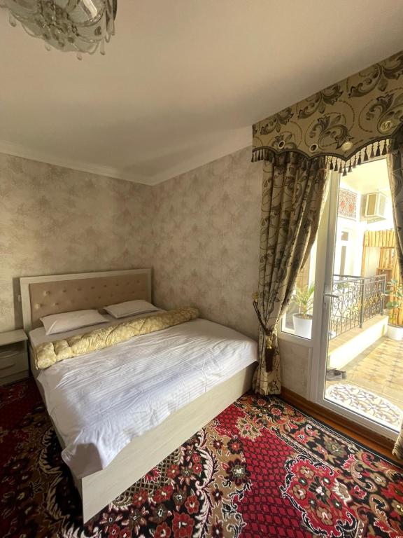 um quarto com uma cama e uma janela em Isfandiyor Hotel em Samarkand