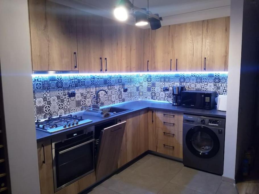 a kitchen with a stove and a sink and a washer at Hightower Apartment in Floreşti